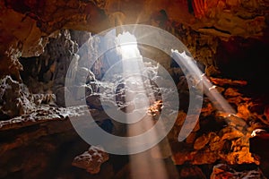 Paprsek z slunce lesklý přes díra jeskyně 