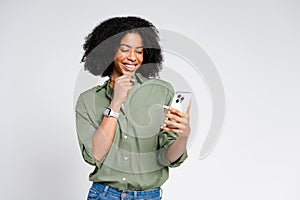 A beaming African-American woman engaging with her smartphone exudes confidence and happiness