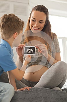 Beaming appealing woman talking with son about chilbirth