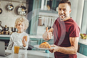 Beaming bearded man feeling happy spending nice family morning