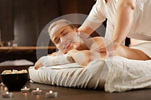 Beaming blonde woman being in great mood during massage session