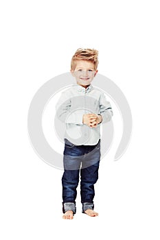 Beaming with boyhood confidence. A cute little boy looking at the camera with his hands clasped.