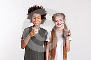 Beaming curly boy carrying glass with milk