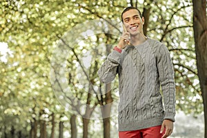 Beaming dark-haired guy in red pants having phone call