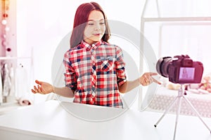 Beaming dark-haired little blogger telling her followers about day in school