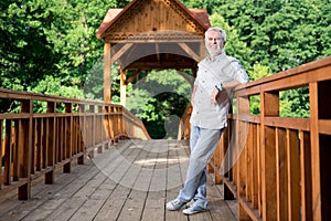 Beaming elderly man wearing comfortable clothes and shoes