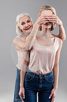 Beaming grey-haired old woman being contented while closing eyes