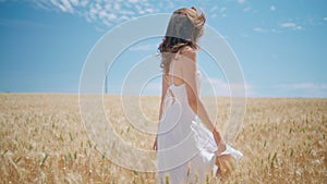 Beaming lady walking sunny wheat farmland. Happy girl spinning summer nature