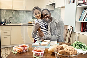 Beaming loving father hugging his cute little daughter