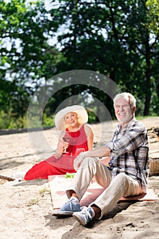Beaming relaxed pensioners feeling very happy having picnic