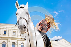 Beaming schoolgirl enjoying her horse riding lesson