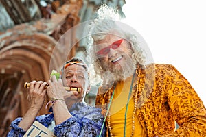 Beaming smiling hippies wearing bright stylish shirts