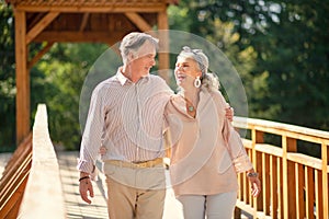 Beaming wife laughing while walking with her man