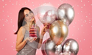 A beaming woman with dark hair, wearing a sequin silver dress