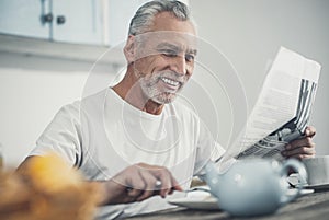 Beaming wrinkled man enjoying his morning at home