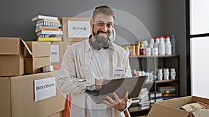 Beaming young hispanic man working away confidently at the charity center, magically transforming donations into community support