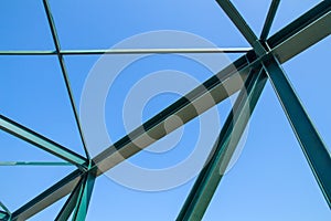 Beams of the steel bridge construction on the blue sky background,metal framework of the structure