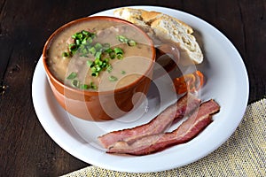Bean broth with herbs bread and bacon in a porcelain bowl, typical brazilian food, bean soup photo