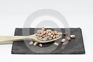 Bean pint or bean with wooden spoon on slate plate photo
