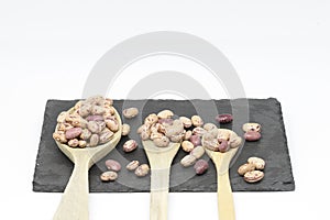 Bean pint or bean with wooden spoon on slate plate and white background photo