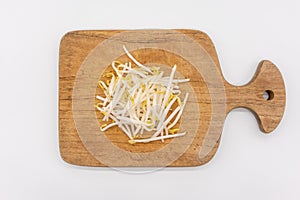 Bean sprouts on wooden chopping board isolated on white