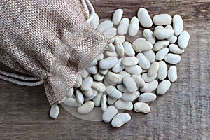 Beans in a bag on a wooden background