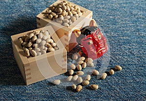 Beans for bean-throwing and masks of ogres placed on a navy blue background. Japanese ogres