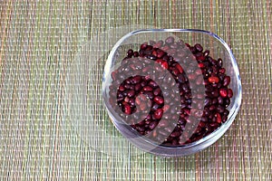 Beans in a glass cup standing on a straw mat