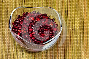 Beans in a glass cup standing on a straw mat