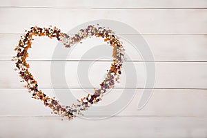 Beans, lentils and beans laid out in the form of a heart on a white wooden background