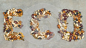 Beans, lentils, mung bean, peas are laid out on a on the concrete background, in the form of the inscription . Vegetarian Food