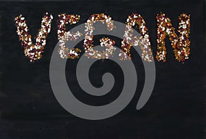 Beans, lentils, mung bean, peas laid out on a white wooden background in the form of the inscription VEGAN. Vegetarian Food