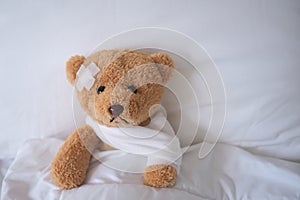 bear with bandage, child medical care . injured child teddy bear and painful in hospital, fell ill in the bed, accident, insurance