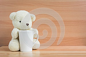 Bear and cup on brown wood background