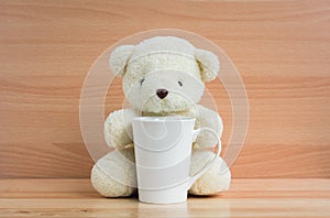 Bear and cup on brown wood background