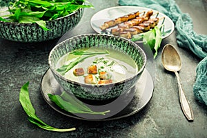 Bear leek soup or ramson soup with crouton, sour cream and turkey skewer