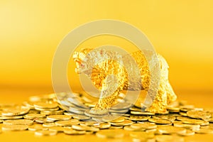 Bear walking over crypto coins against golden background. Market downtrend concept