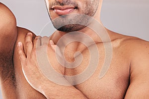 Beard, armpit and body skincare of man in studio isolated on a gray background. Hygiene, grooming and chest hair removal