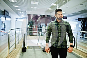 Beard indian guy with mobile phone pose at trade center against escalator