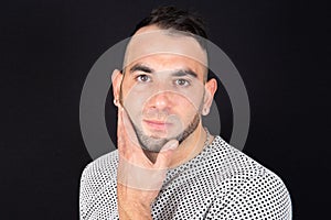 Beard man hand on chin portrait in black background