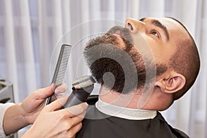 Beard trimming in barbershop.