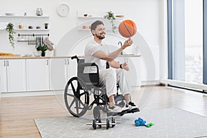 Bearded adult with mobility impairment dribbling ball in studio apartment.