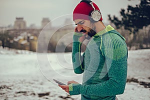 Bearded athlete listening music outdoor