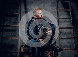 The bearded backpacker male sits on a wooden box.