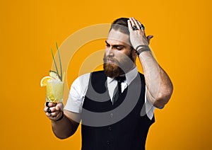 Bearded barman with beard holding cocktail in waistcoat