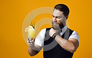 Bearded barman with beard holding cocktail in waistcoat