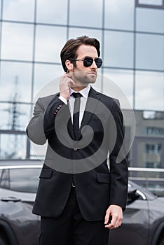 bearded bodyguard in suit and sunglasses