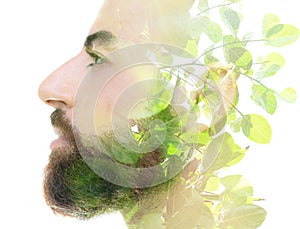 A bearded bold man profile double exposure portrait close up combined with a photo of young tree branches