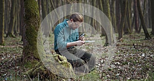 Bearded botanist exploring moss with magnifying glass