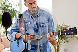 bearded brunette man in casual denim jacket play acoustic guitar, singing